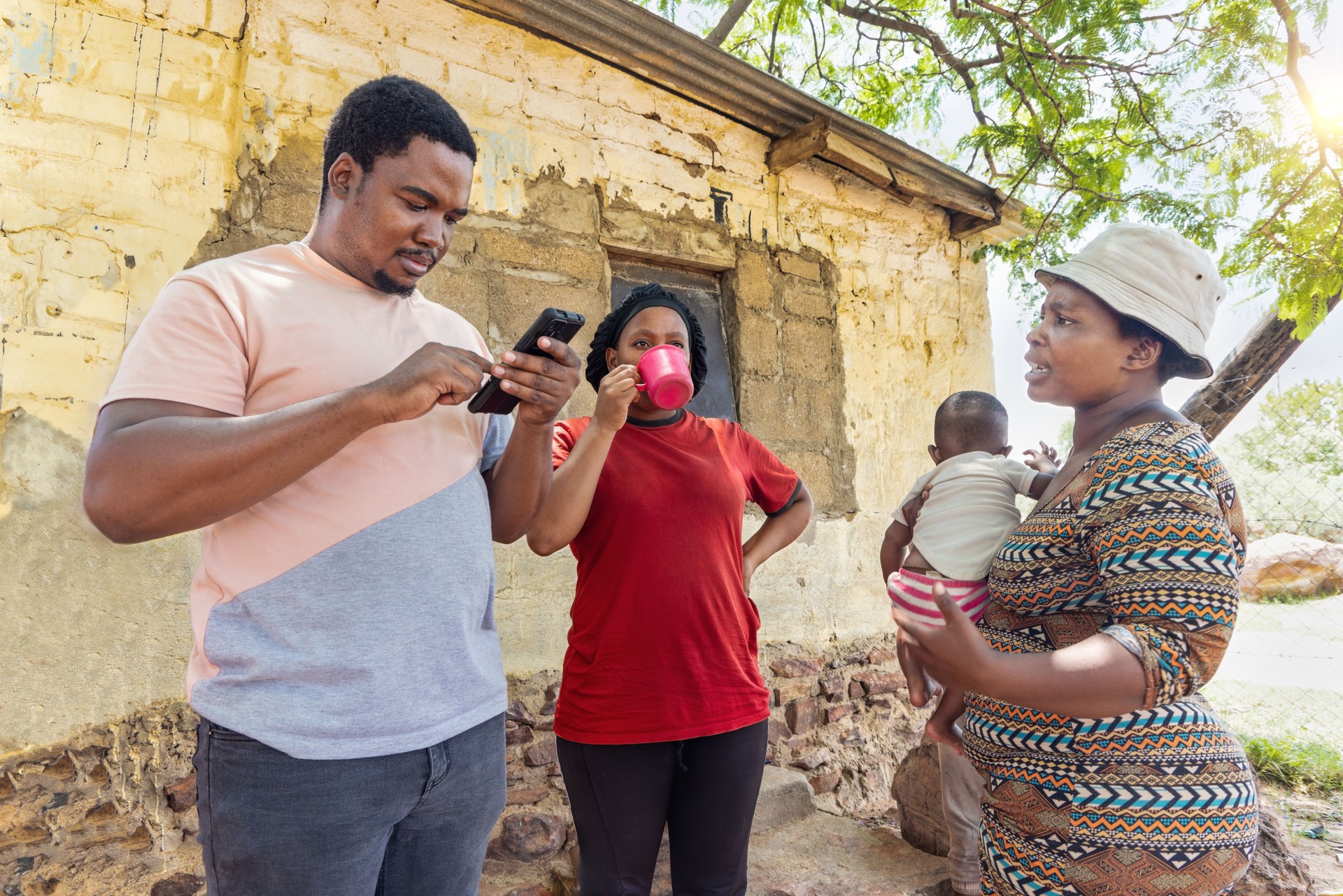 african social worker volunteer with a phone educating the villagers in a remote village in Botswana,